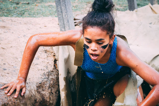 A woman in the outdoors, mouth open as if gasping for breath.