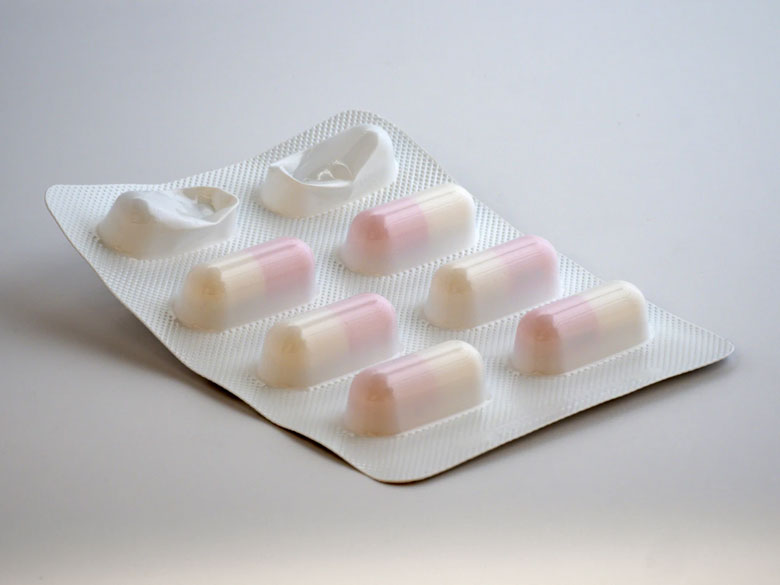 A blister pack with two capsules popped out.