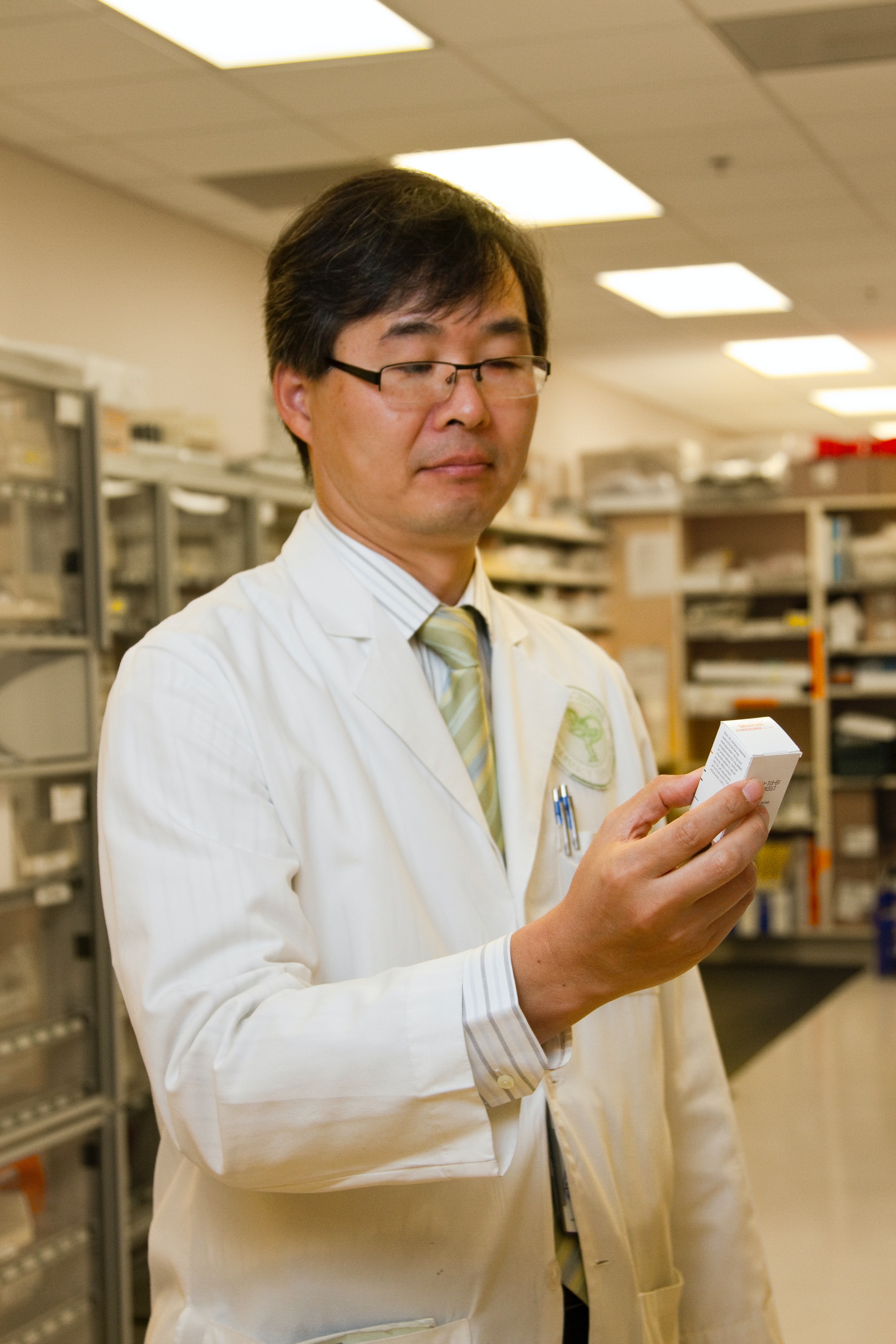 A pharmacist in a legit online pharmacy carefully checking a box for the correct medication and strength.