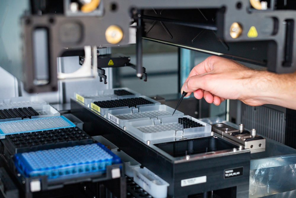 Plastic trays containing drug vials placed on machines in a pharmaceutical manufacturing facility