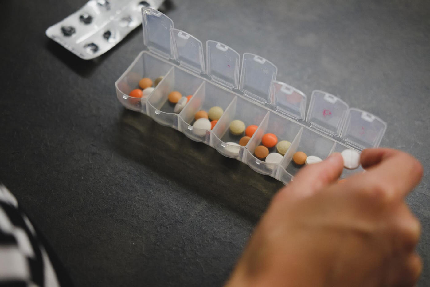 Image of someone with their daily medicine container