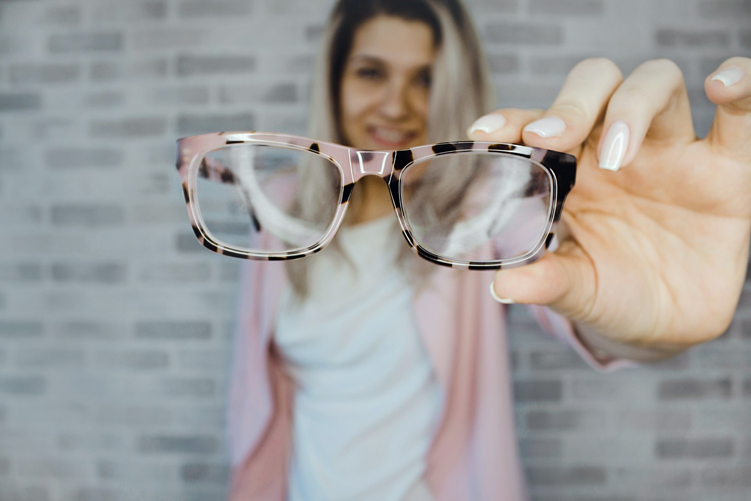 A woman holding eyeglasses